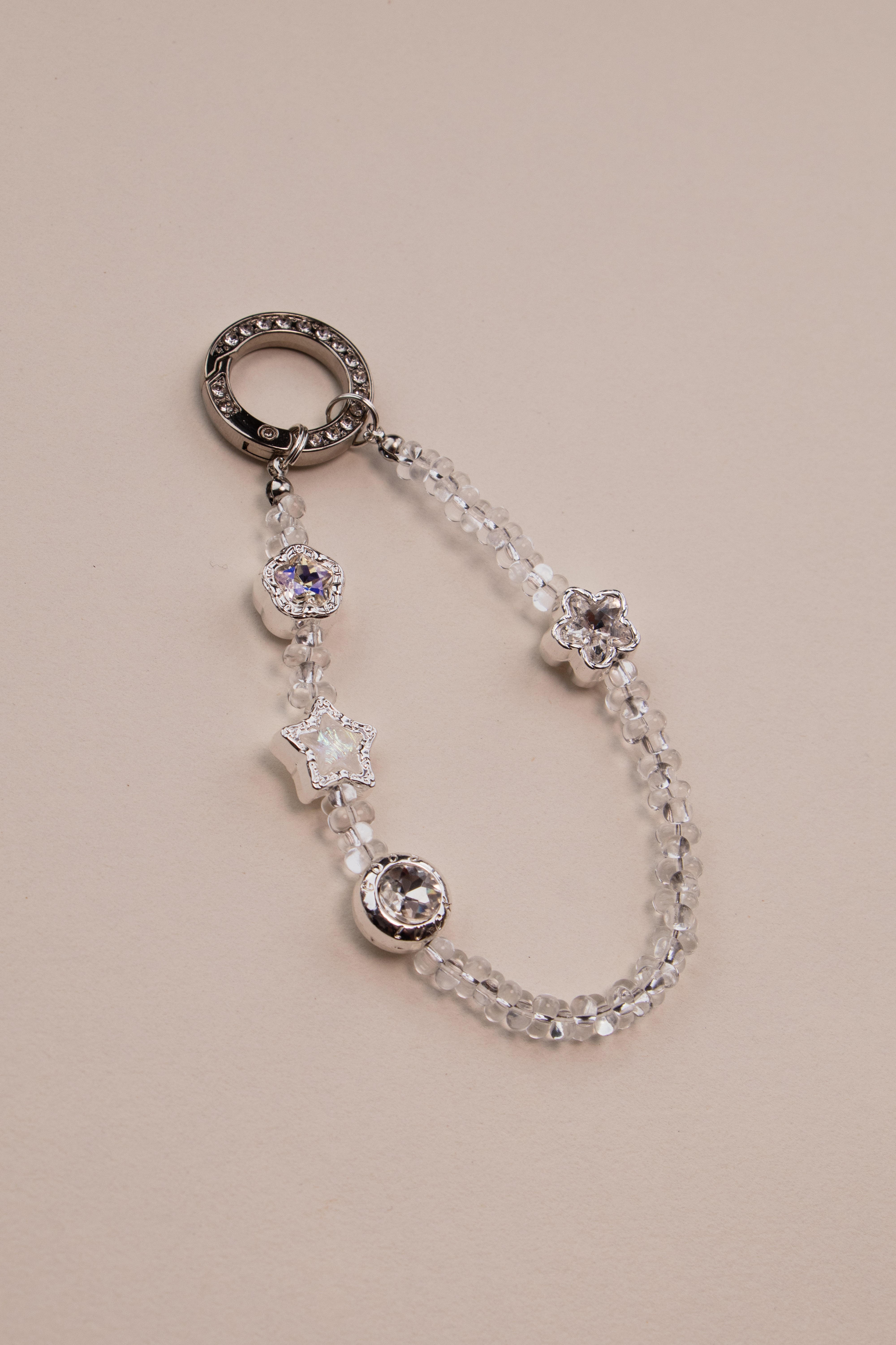 Crystal star beaded phone charm with silver rhinestone ring on white background
