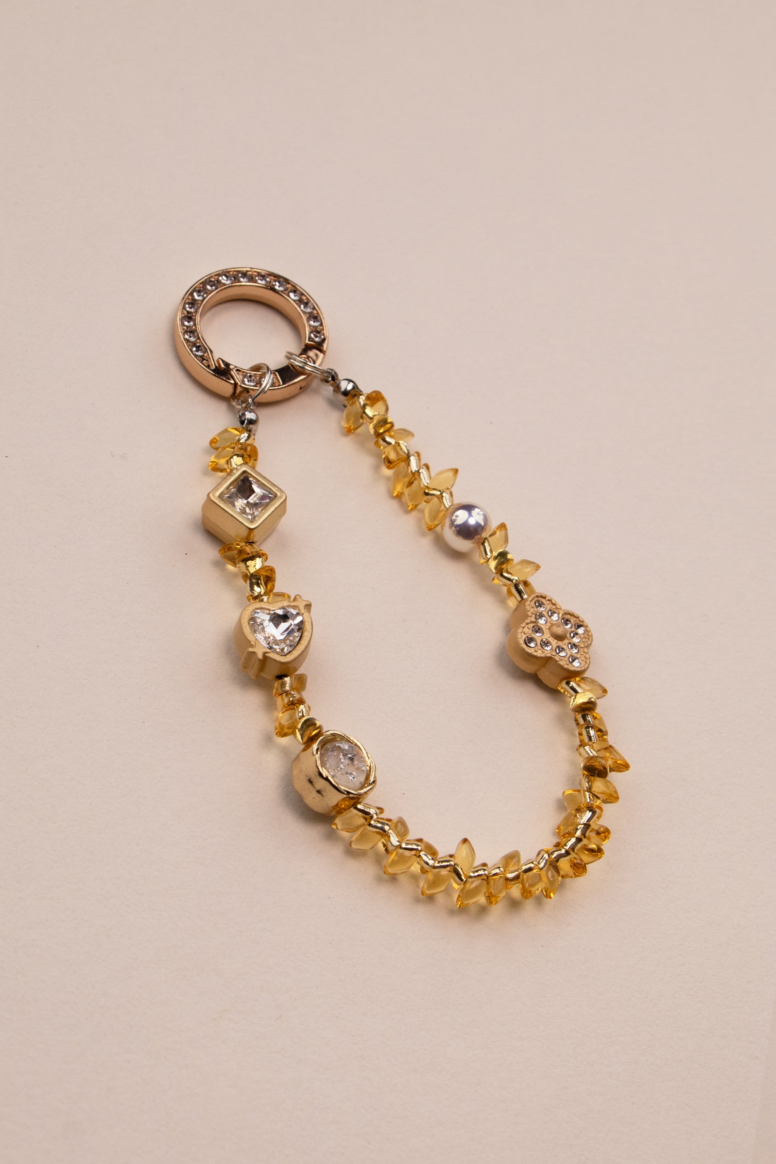 Honey Light beaded phone charm with golden amber beads on neutral background