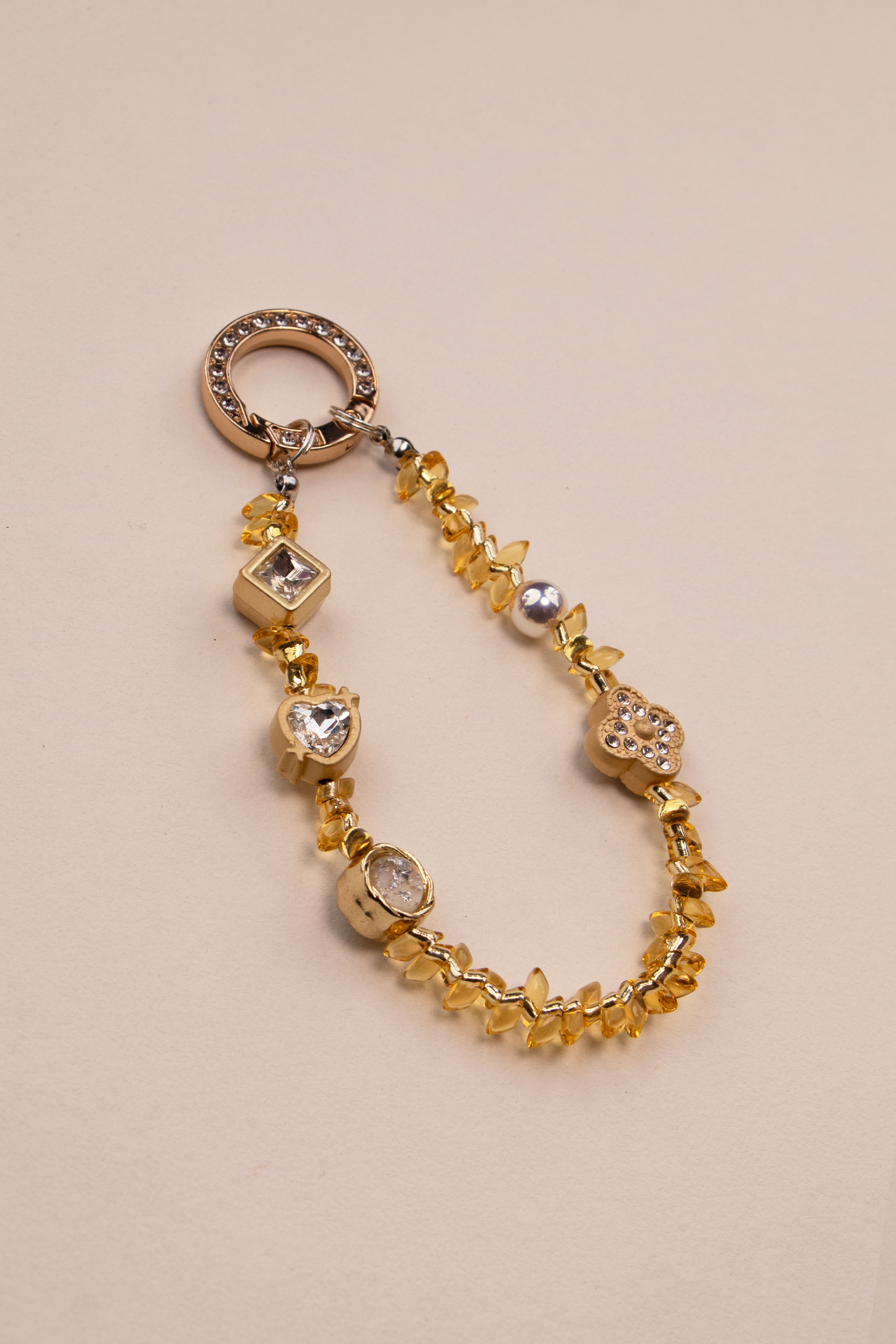 Honey Light beaded phone charm with golden amber beads on neutral background
