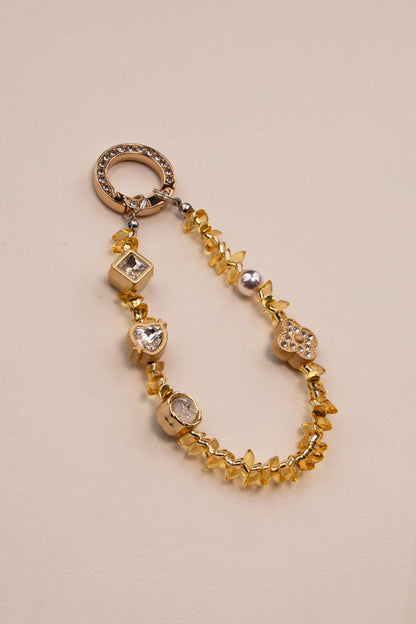 Honey Light beaded phone charm with golden amber beads on neutral background