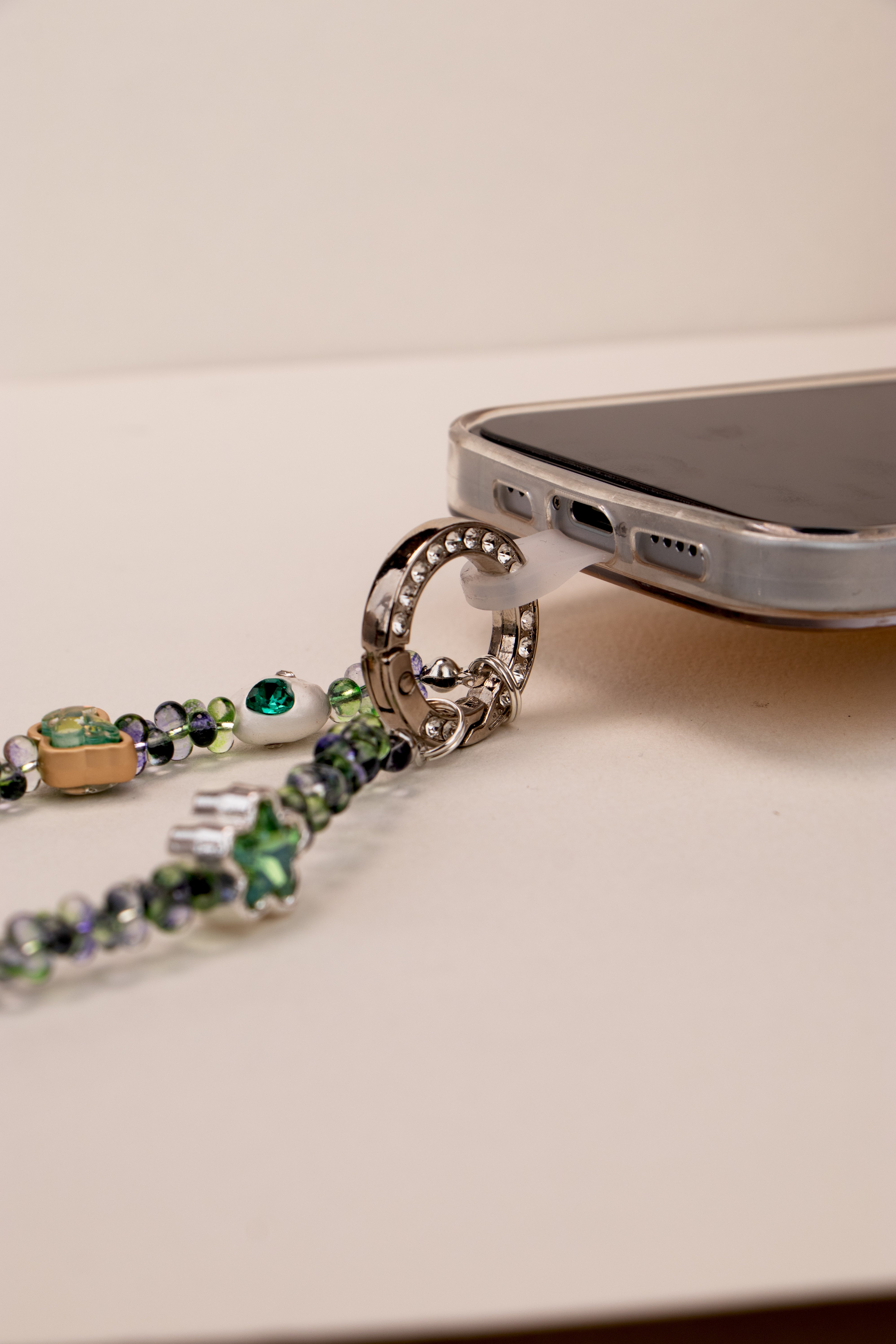 Phone tether tab attached to Green Whisper phone charm on phone case