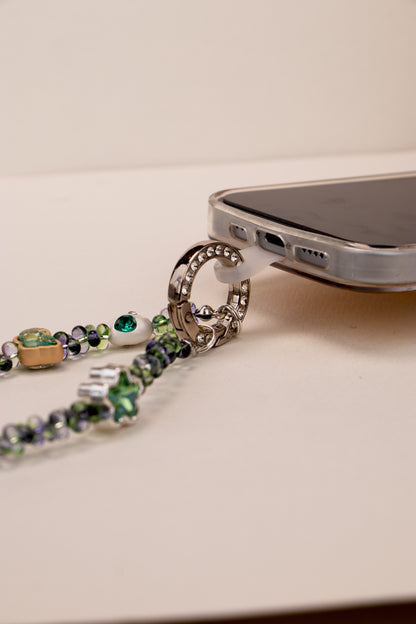 Phone tether tab attached to Green Whisper phone charm on phone case
