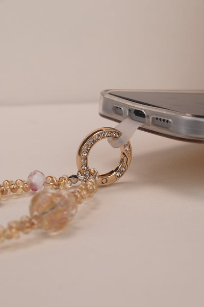 Phone tether tab attached to Golden Bloom phone charm on phone case