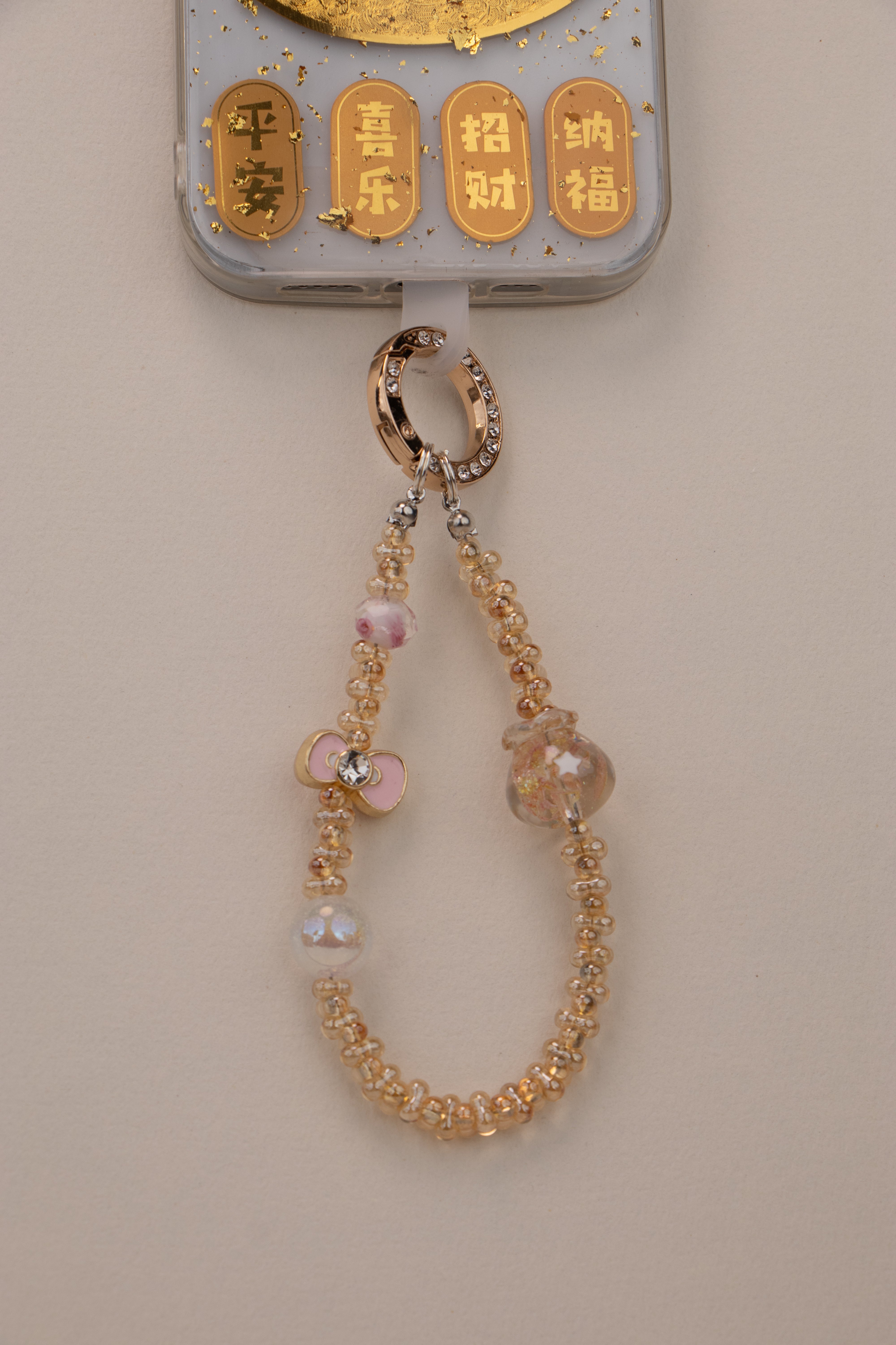 Golden Bloom beaded phone charm attached to phone with included tether tab