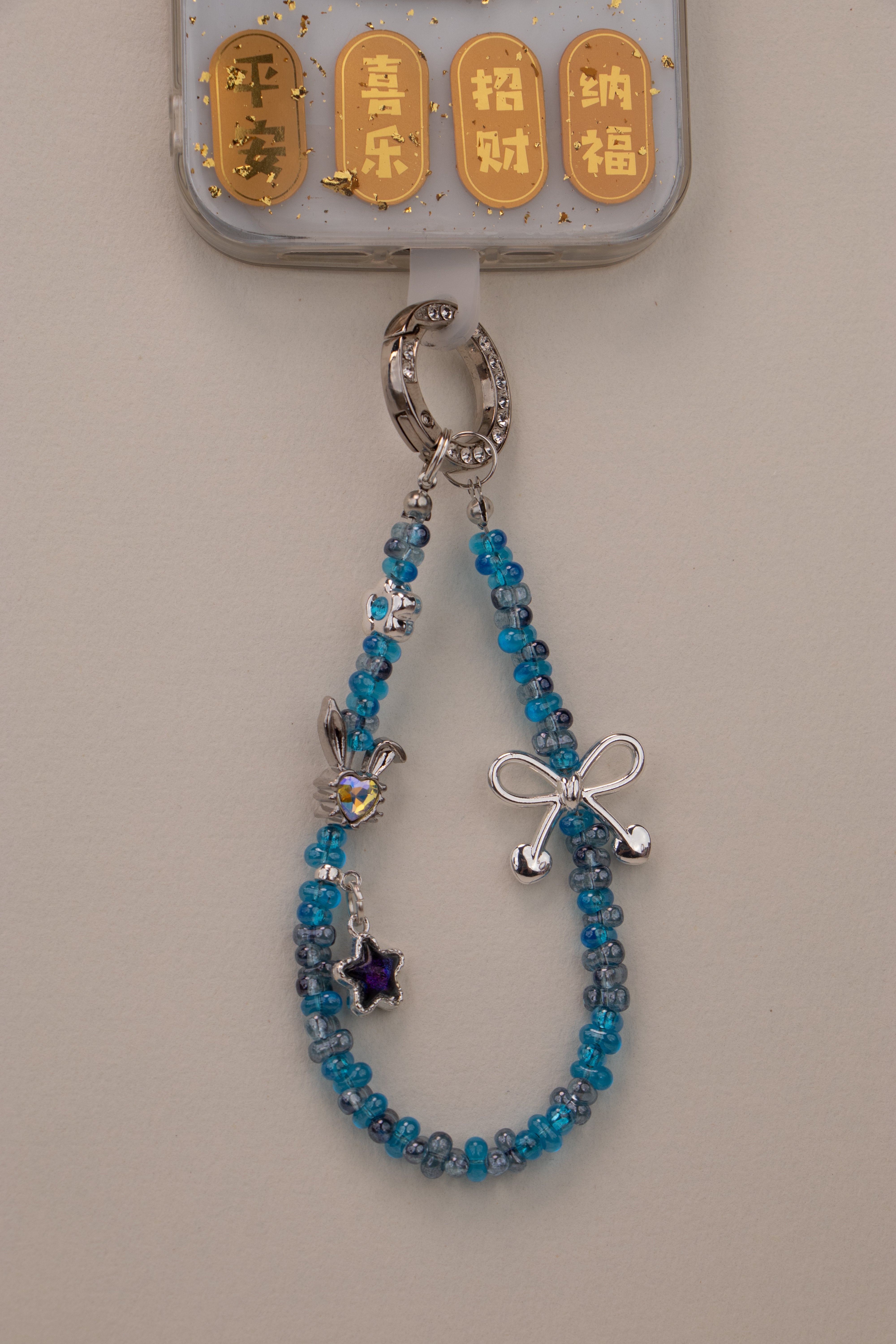 Blue Ribbon beaded phone charm attached to phone with included tether tab