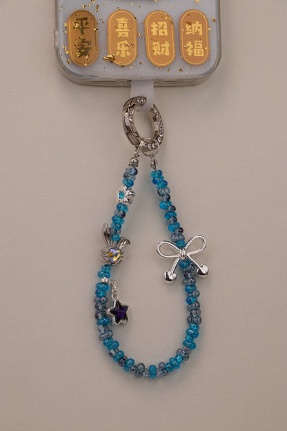 Blue Ribbon beaded phone charm attached to phone with included tether tab
