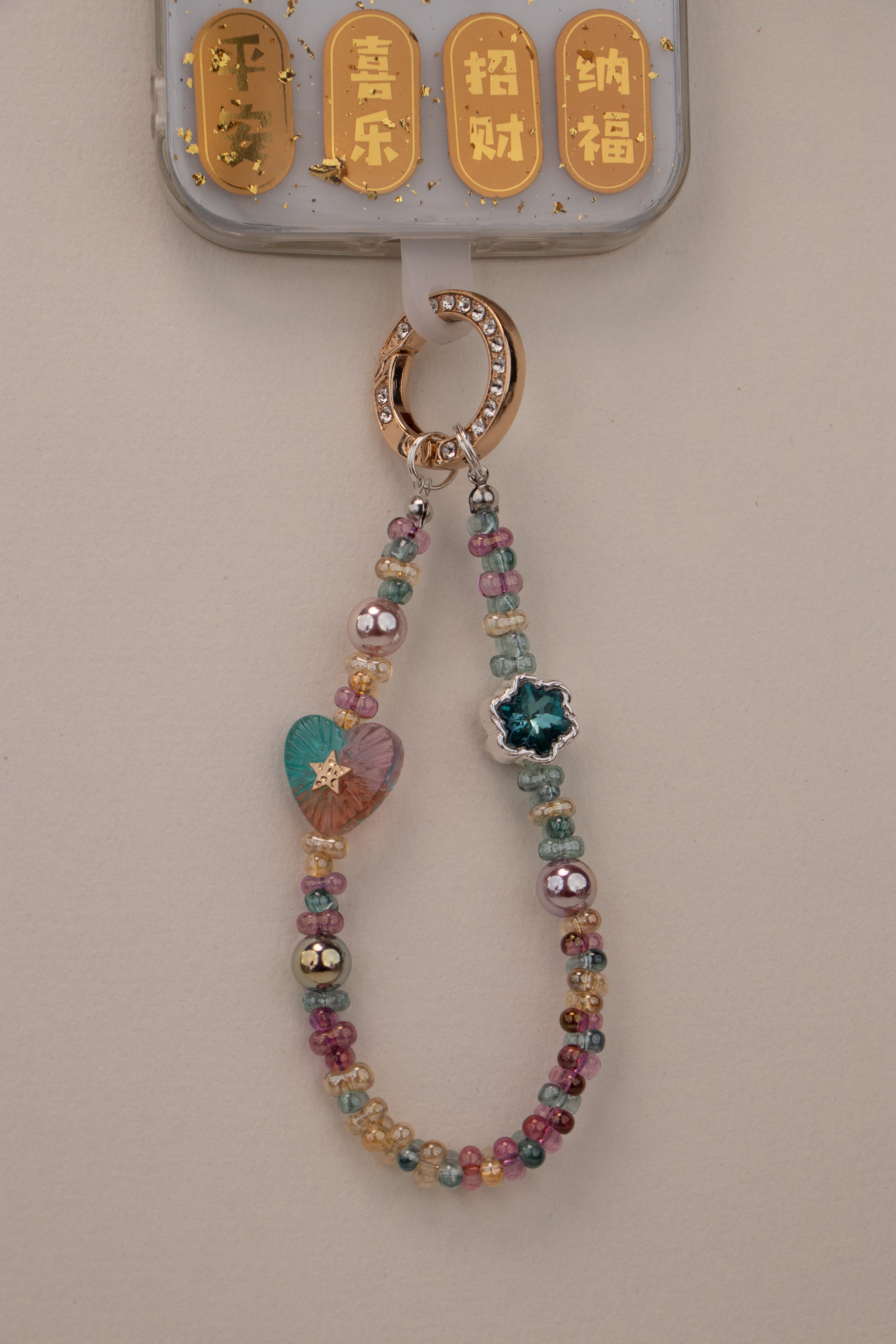 Daydream Heart beaded phone charm with gold-tone rhinestone ring on white background