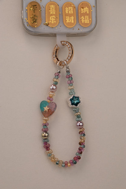 Daydream Heart beaded phone charm with gold-tone rhinestone ring on white background