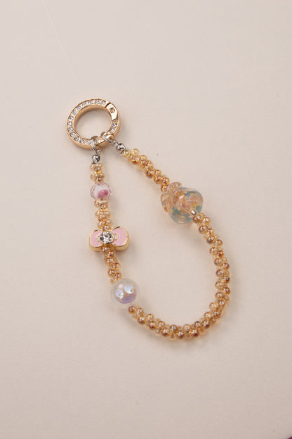 Golden Bloom beaded phone charm with warm golden beads on white background