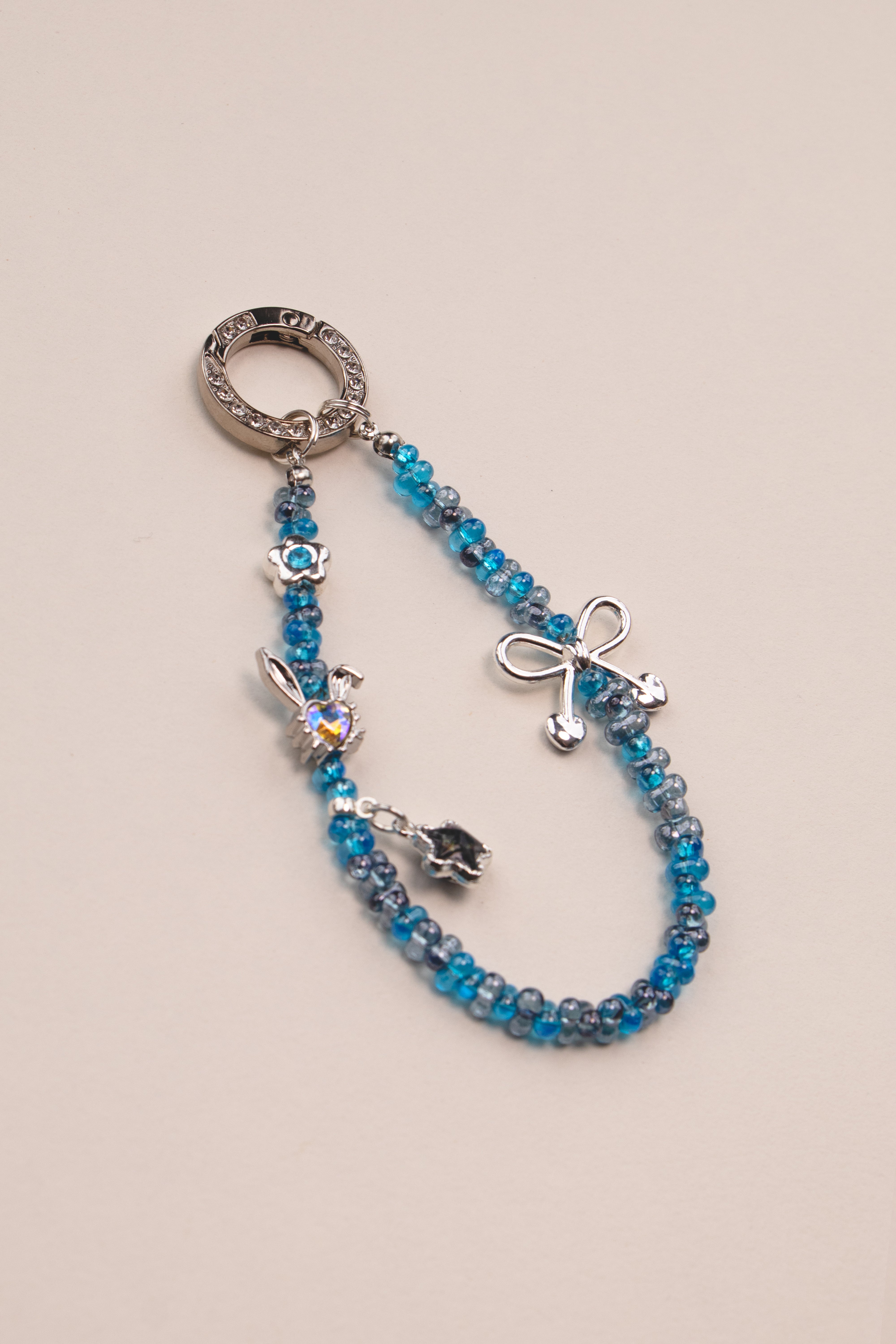 Blue Ribbon beaded phone charm with blue beads on neutral background