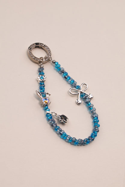 Blue Ribbon beaded phone charm with blue beads on neutral background