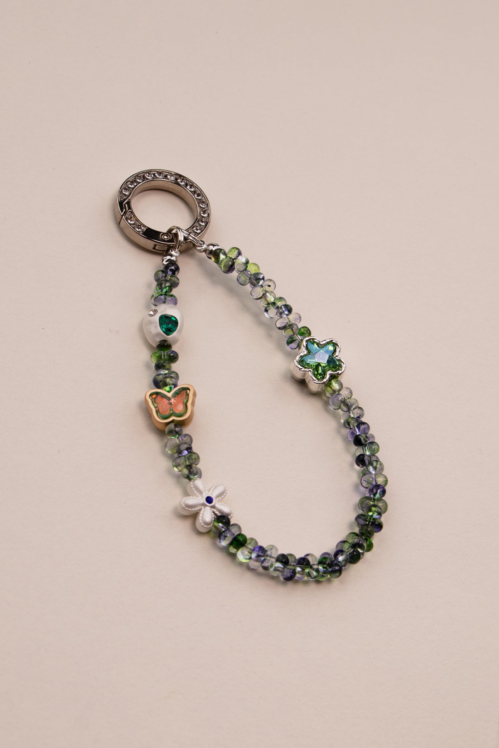 Green Whisper beaded phone charm with green beads on neutral background