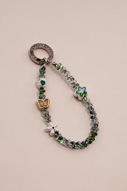 Green Whisper beaded phone charm with green beads on neutral background