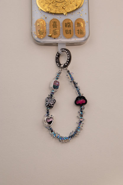 Midnight Flutter beaded phone charm with dark ring on neutral background