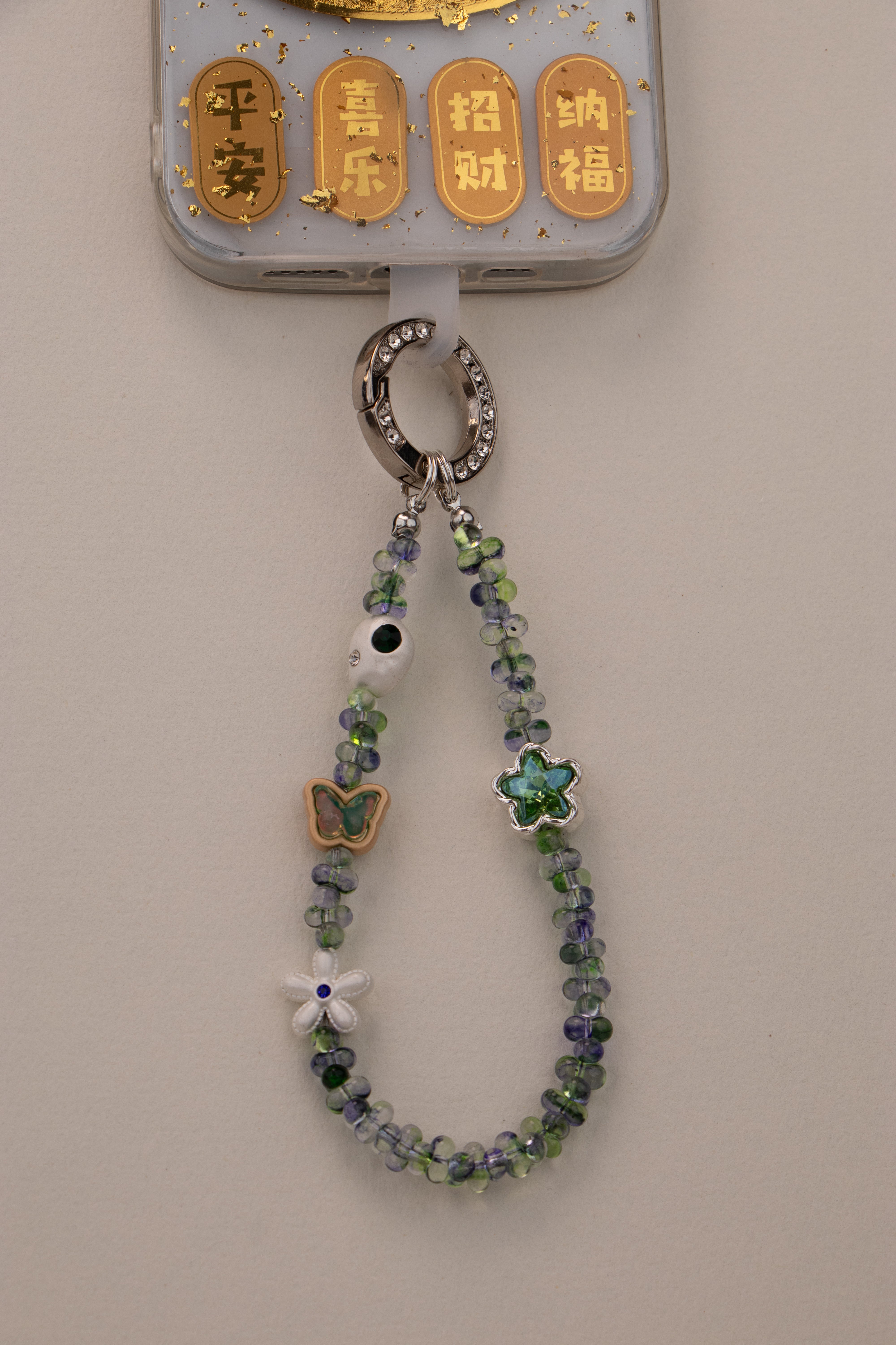 Green Whisper beaded phone charm attached to phone with included tether tab