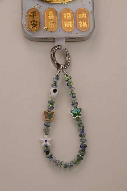 Green Whisper beaded phone charm attached to phone with included tether tab